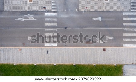 Aerial zenithal view of an empty road with road signs on the ground. Royalty-Free Stock Photo #2379829399