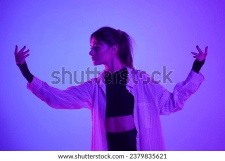 Young woman performing contemporary dance in studio. Neon pink and purple color scheme, ombre, gradient background. Medium sized.
