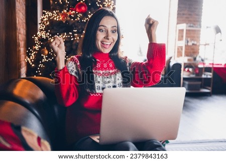 Photo of overjoyed cheerful girl rejoicing good news seasonal special discount sitting comfy sofa room indoors
