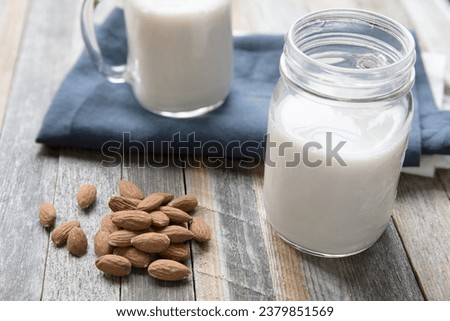 This picture of almond nut with milk in jar and beautiful wood table in this picture.