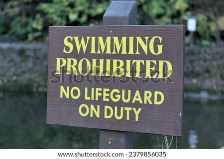swimming prohibited no lifeguard on duty sign at famous swimming hole (waterfall in ithaca) safety, life guard, drowning threat, water sport, swim, summer (no swimming allowed)