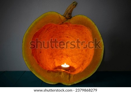 Candle burning inside a cleaned pumpkin, carved interior , abstract texture, soft focus close up
