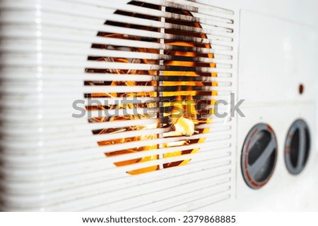 Electric fan heater exploding with sparks and flames, burning plastic,  domestic short circuit concept Royalty-Free Stock Photo #2379868885