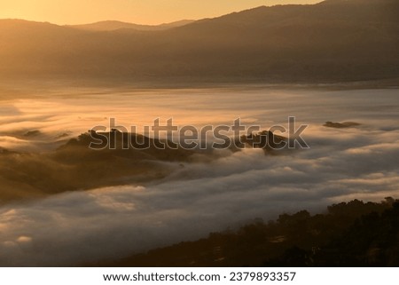 beautiful sunrise in the  Pleasanton foothills with fog flowing around them