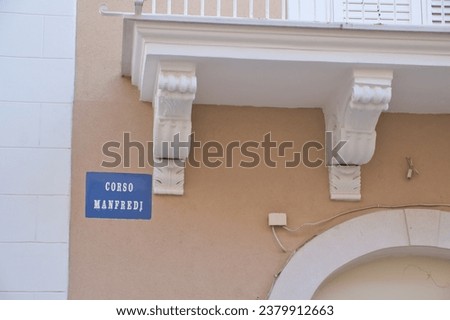 A sign with the street name Corso Manfredi on a house facade in Manfredonia, Apulia, Italy