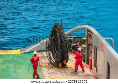 Procced loading of pennant wire, anchor buoy by ship crew to be used for anchor handling or anchor job activities Royalty-Free Stock Photo #2379915571