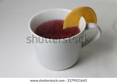 hot tea with smoking oranges in a white mug on a white background