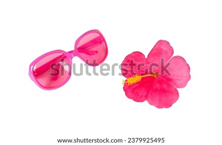 Pink sunglasses and a pink tropical flower isolated on a white background