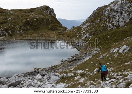 Adult Woman Hiking on Luznica Lake or the third lake of Krn that  is a glacial lake in the Triglav national park of Slovenia