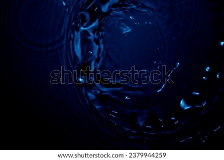 The deep blue surface of the water rippled softly. Splashing water droplets create a moving and calm curve. can be made into wallpapers and backgrounds.