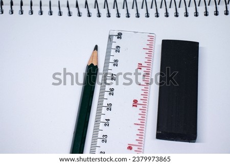 pencil, eraser and ruler on a sketchbook