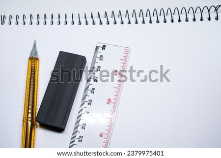 mechanical pencil, eraser and ruler on a sketchbook