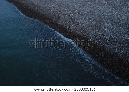 Black Sea. water wave on pebble beach shore. Batumi, Georgia. top view on blue aqua surface.  top aerial view.  Sea blue water wave on pebble beach shore. diagonal. 