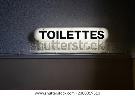 a glowing toilet sign in one of the bars