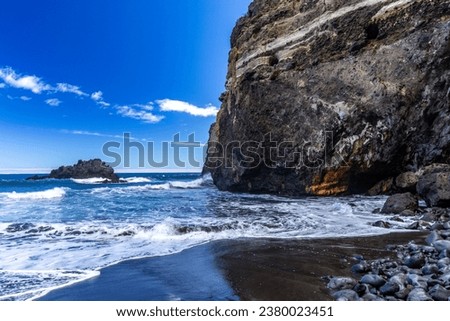 Beach with black volcanic sand, green palm trees on the slope, dangerous waves, Atlantic Ocean, Castro Beach Playa Castro Teneriffe Spain