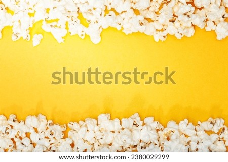 Popcorn on yellow background. Movie or TV background, border, frame. Top view Copy space