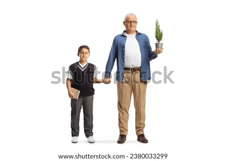 Full length portrait of a man with a small tree in a pot holding a schoolboy by the hand isolated on white background
