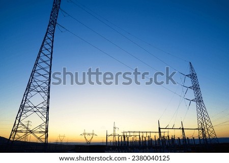 Electrical substation for energy distribution and orange sky Royalty-Free Stock Photo #2380040125