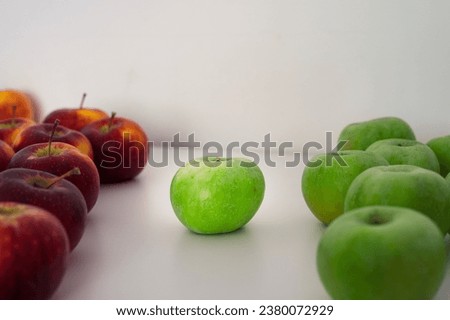 Two groups of green and red apples. One apple in the center. Organic fresh fruits and image of autumn harvest