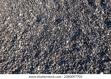 Background of sea stones. Close-up of stones of different shapes and sizes on the beach