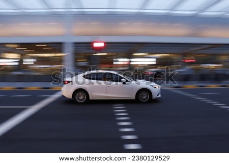 Speeding white car passing by on the road