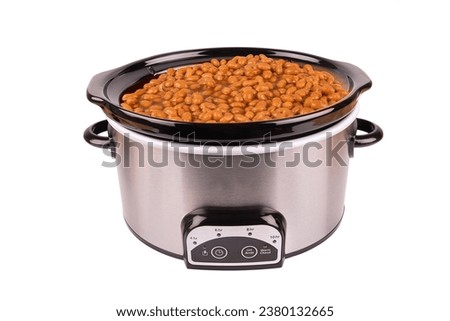 Beans cooking in a stainless crock pot isolated on a white background, cut out. Royalty-Free Stock Photo #2380132665