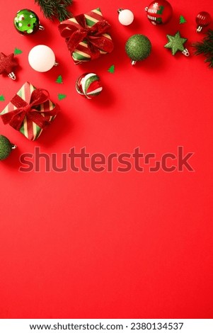 Christmas red vertical background with gift boxes, balls, confetti. Flat lay, top view, copy space.