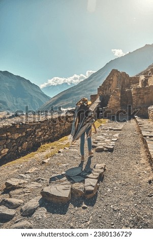 Traveler hipster girl in hat with backpack exploring ruins of Ollantaytambo Ruins in Sacred Valley of Peru Royalty-Free Stock Photo #2380136729