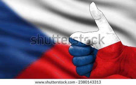 hand with thumbs up in approval with the czech flag painted. Image with flag background area out of focus, copy space area