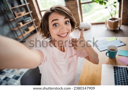 Selfie shooting young businesswoman bob hair thumb up recommendation her first job intern working remote from coworking zone background