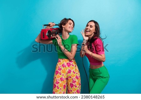Photo of pretty dreamy ladies wear colorful clothes enjoying boom box songs singing karaoke isolated blue color background
