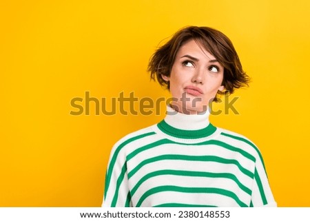 Photo of doubtful unsure lady wear striped pullover looking empty space isolated yellow color background