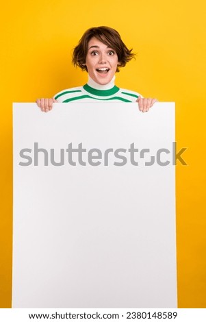 Vertical picture of young girl bob brown hair wear striped turtleneck hold paper white banner ad mockup isolated on yellow color background