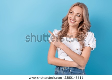 Photo of young girl blonde wavy hairstyle recommend shopping center advertisement indicate finger novelty isolated on blue color background