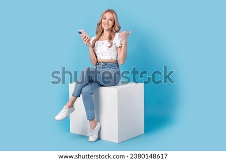 Full length photo of shiny tricky woman dressed white top chatting modern gadget thumb empty space isolated blue color background