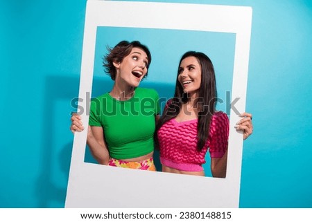 Photo of positive impressed ladies wear colorful clothes shooting photo portrait together isolated blue color background