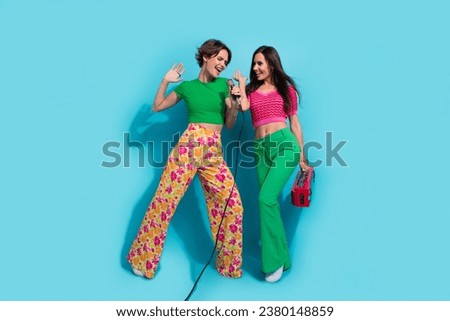 Full length size photo of karaoke entertainment excitement two funny positive girls music lovers concert isolated on blue color background