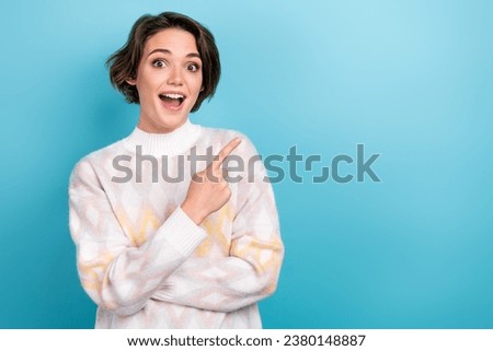Photo portrait of pretty young girl excited finger point empty space wear trendy white outfit isolated on blue color background
