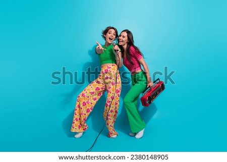 Full body photo of weekend girlfriends sing microphone bring retro old school boombox pointing select you isolated on blue color background