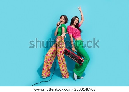 Full body photo of two pretty girls concert beautiful famous celebrity singing microphone sound boombox isolated on blue color background
