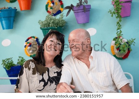 Portrait of happy bonding family couple sitting in a flowered patio enjoying relaxed moments