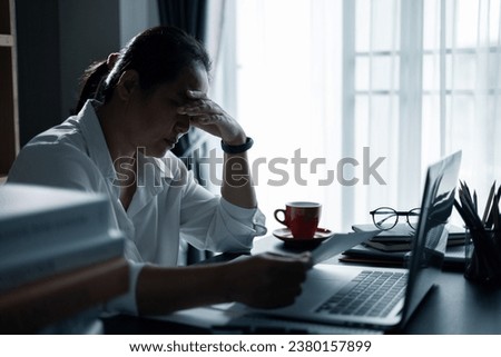 Hard think on analysis in the work. Young asian business woman is working on pressure in office. Tired business woman sleepy and bored from sitting at a desk for a long time and has office syndrome.
