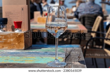 Drinking of pinot grigio dry cold wine, served outdoor in beach cafe in North Holland, North sea sandy beach, the Netherlands