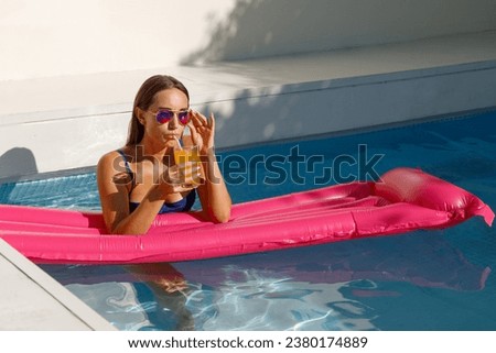 Poolside Elegance: Young Woman Relaxing with Pink Mattress