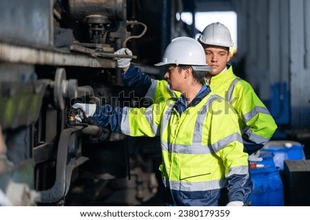 Team railway engineer Inspect repair project train diesel engine in maintenance center. Technician discuss planning checking vehicle and railroad systems. Royalty-Free Stock Photo #2380179359