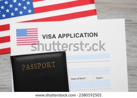 Immigration to USA. Visa application form, passport and flag on light wooden table, flat lay Royalty-Free Stock Photo #2380192501
