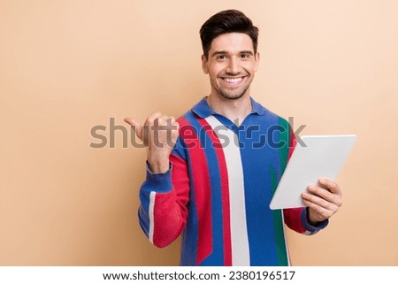 Photo of young marketing specialist businessman hold tablet pointing finger recommend download new app isolated on beige color background