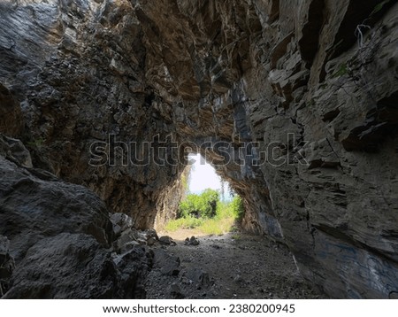 Natural cave, view from inside to outside. natural formations landscape Royalty-Free Stock Photo #2380200945