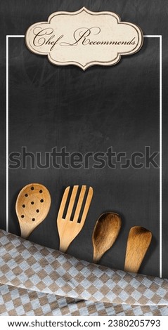 Template for a restaurant menu with empty blackboard, brown and white checkered tablecloth, wooden kitchen utensils, label with text Chef Recommends and copy space.