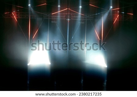 Stage lighting with laser illumination and puffs of smoke. Dark stage background.